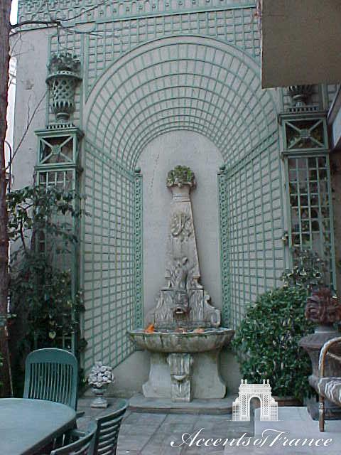 Custom latticework designed to create a focal point around a fountain with the use of a trompe l'oeil panel.